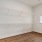 a room with a wood floor and a white wall with a window